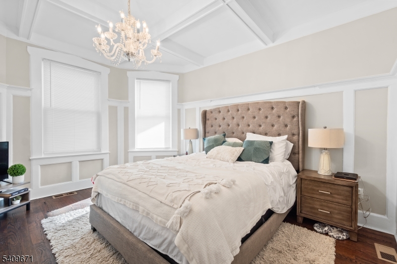 33 Mapes Avenue, Unit 2 Newark, NJ 07112 - Photo 4 of 40 a bedroom with a bed and a chandelier