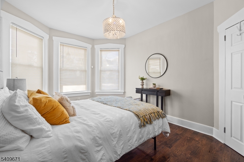 33 Mapes Avenue, Unit 2 Newark, NJ 07112 - Photo 8 of 40 a bedroom with a bed window and a chandelier