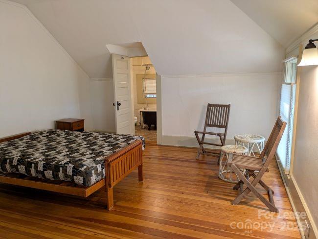 220 Melrose Circle, Unit 2 Tryon, NC 28782 - Photo 3 of 9 a bedroom with a bed and a chair