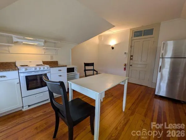 a kitchen that has a table chairs and wooden floor