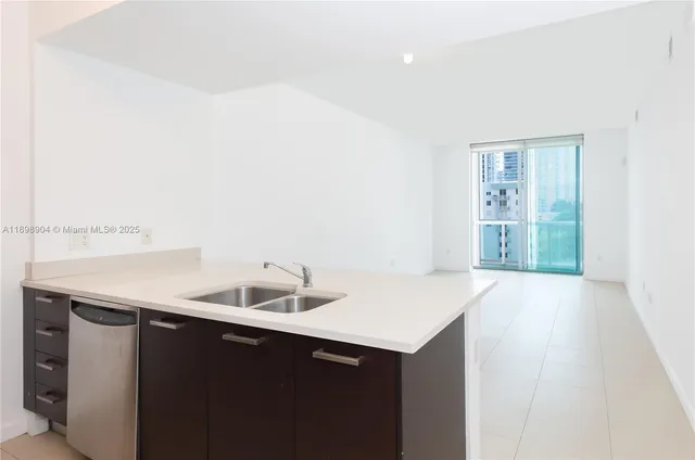 a kitchen with a sink cabinets and a window