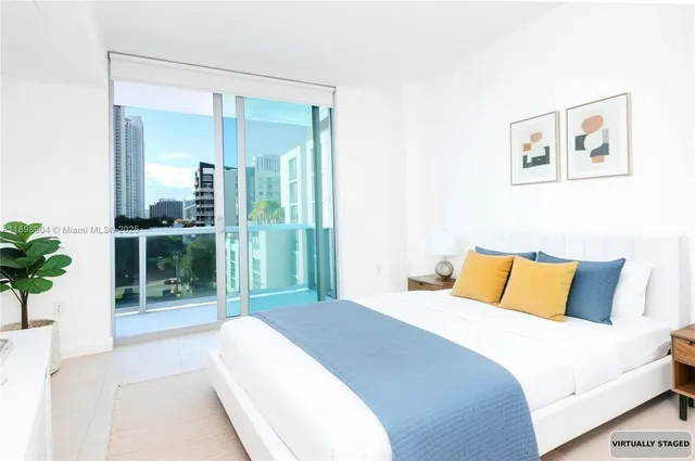 a bedroom with a large bed and a potted plant