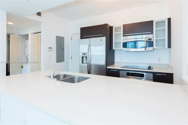a kitchen with stainless steel appliances a sink a stove and a refrigerator