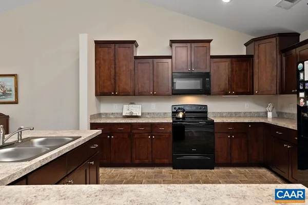 a kitchen with a sink stove and wooden cabinets