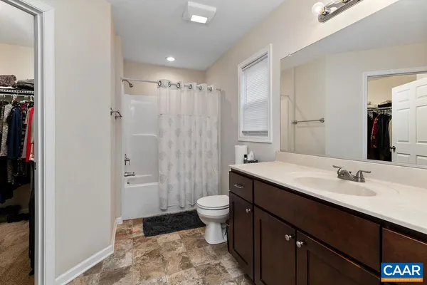 a bathroom with a sink a toilet a shower and a mirror