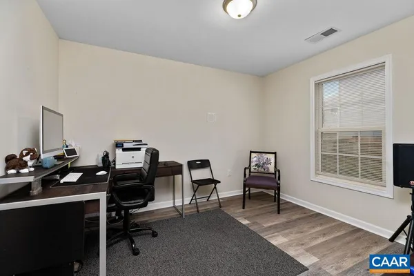 a view of a workspace with furniture and a window