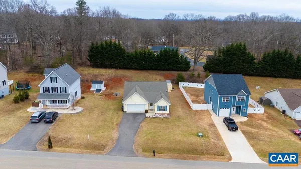 an aerial view of a house with a garden and lake view