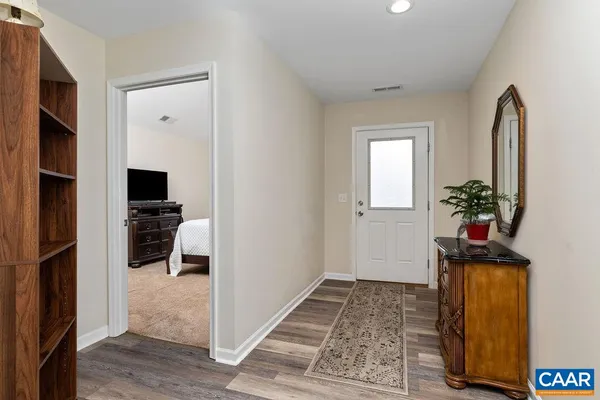 a view of a hallway with wooden floor and a living room