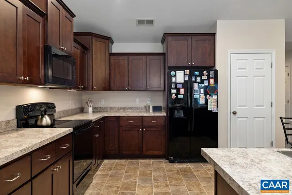 a kitchen with granite countertop wooden cabinets and black stainless steel appliances