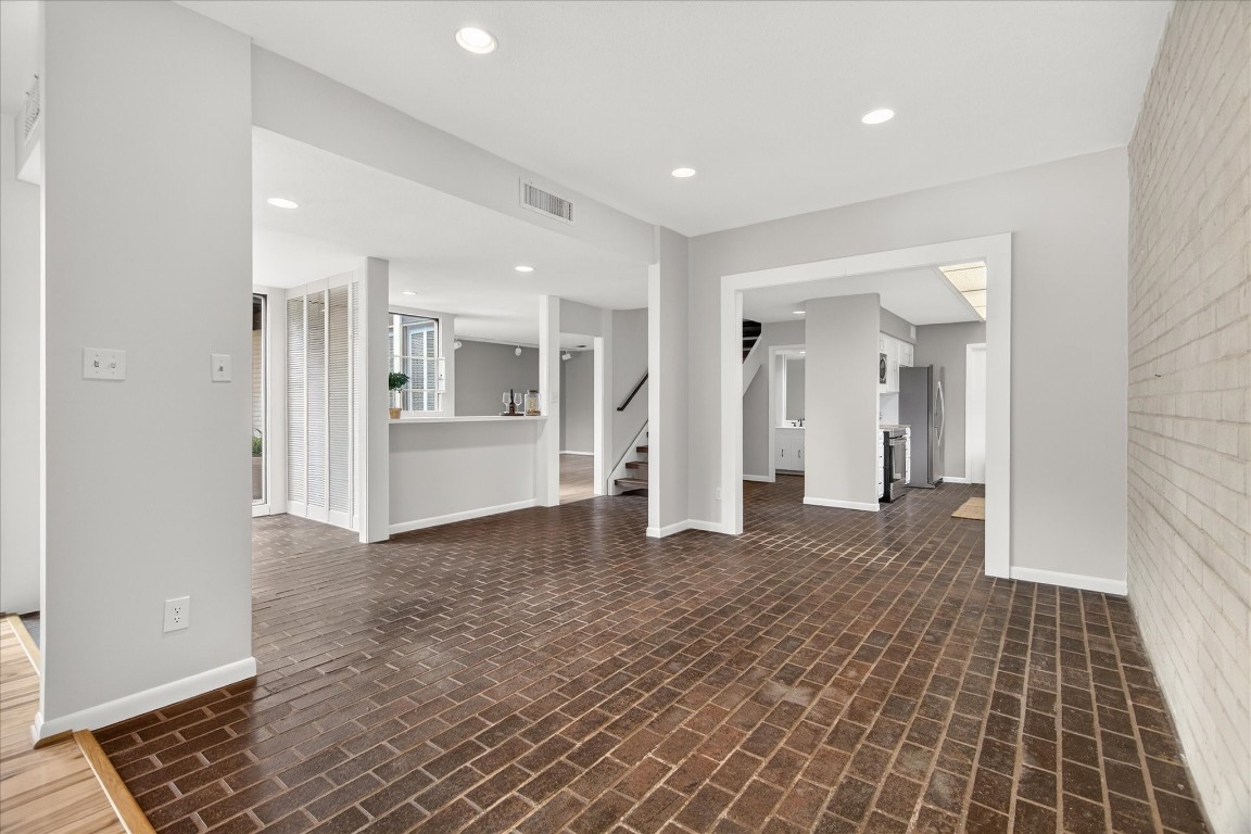 147 Valley Drive Liberty, TX 77575 - Photo 14 of 42 Elegant brick flooring seamlessly connects the entryway, dining area, and kitchen.