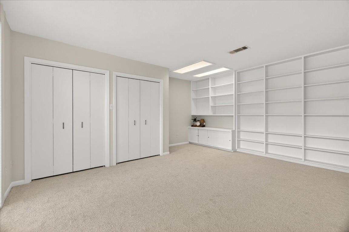 147 Valley Drive Liberty, TX 77575 - Photo 36 of 42 This spacious upstairs bedroom features extensive built-in shelving, perfect for organized living.
