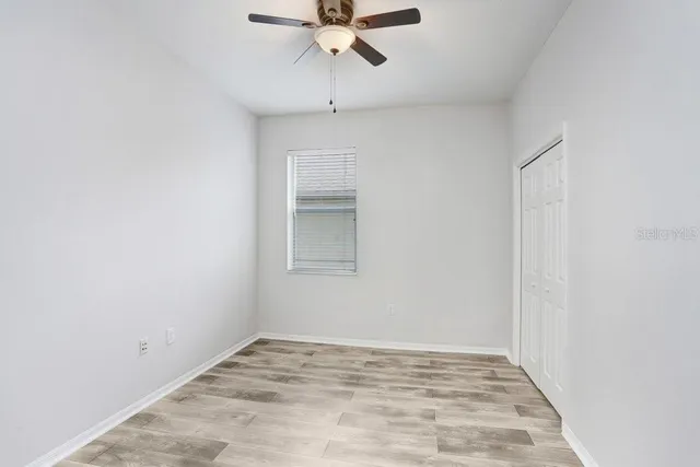 a view of empty room with wooden floor