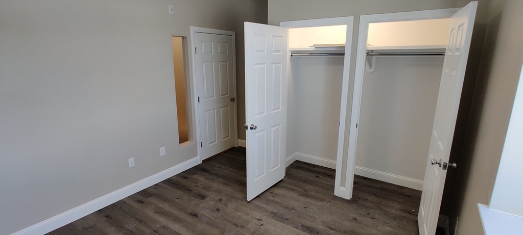 191 North Common Street, Unit 305 Lynn, MA 01905 - Photo 4 of 8 an empty room with wooden floor and a window