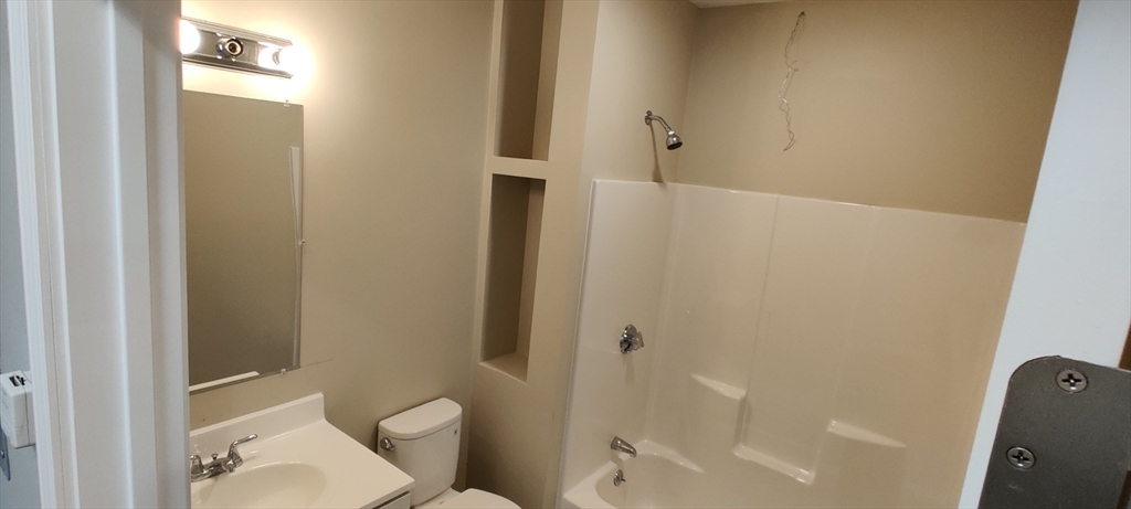 191 North Common Street, Unit 305 Lynn, MA 01905 - Photo 7 of 8 a bathroom with a toilet and shower