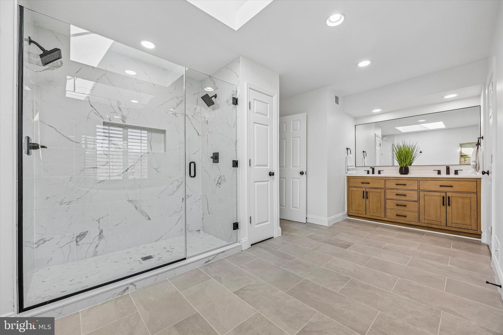 872 Roscommon Road Bryn Mawr, PA 19010 - Photo 26 of 49 a large bathroom with a shower a sink and mirror