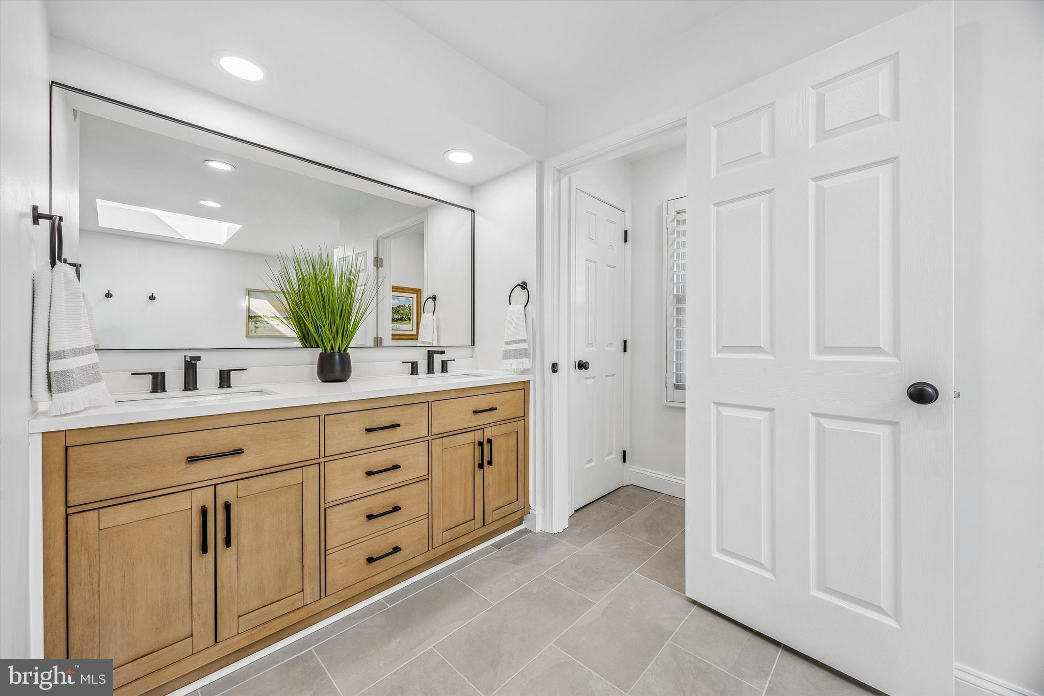 872 Roscommon Road Bryn Mawr, PA 19010 - Photo 27 of 49 a spacious bathroom with a double vanity sink and a mirror
