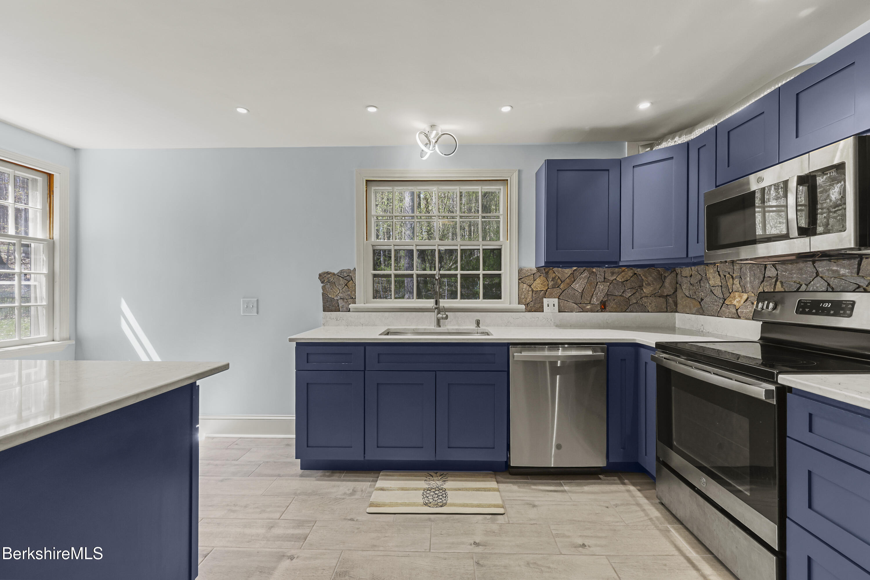 100 South Prospect Street Lee, MA 01238 - Photo 11 of 39 a kitchen with stainless steel appliances granite countertop a stove a sink and a microwave
