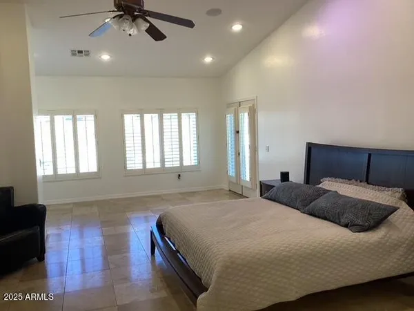 a bedroom with a large bed and a chandelier