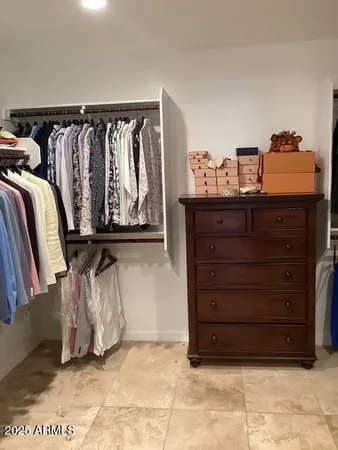 a view of walk in closet with clothes and shoes