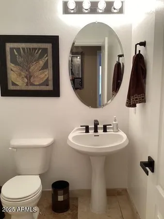 a bathroom with a toilet a sink and mirror