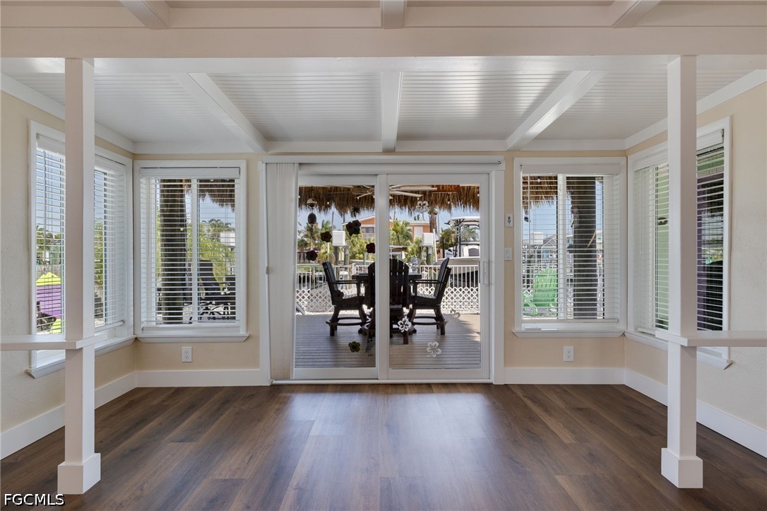 2639 Bridgeview Street Matlacha, FL 33993 - Photo 17 of 28 a dining room with wooden floor a glass table and chairs