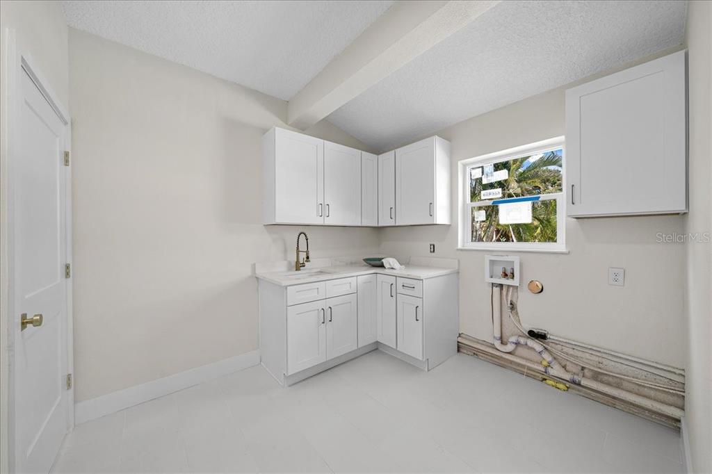 145 Southeast 3rd Street Satellite Beach, FL 32937 - Photo 18 of 29 a kitchen with cabinets appliances a sink and a window