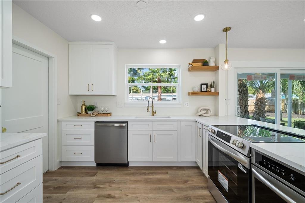 145 Southeast 3rd Street Satellite Beach, FL 32937 - Photo 7 of 29 a kitchen with a stove a sink and a window