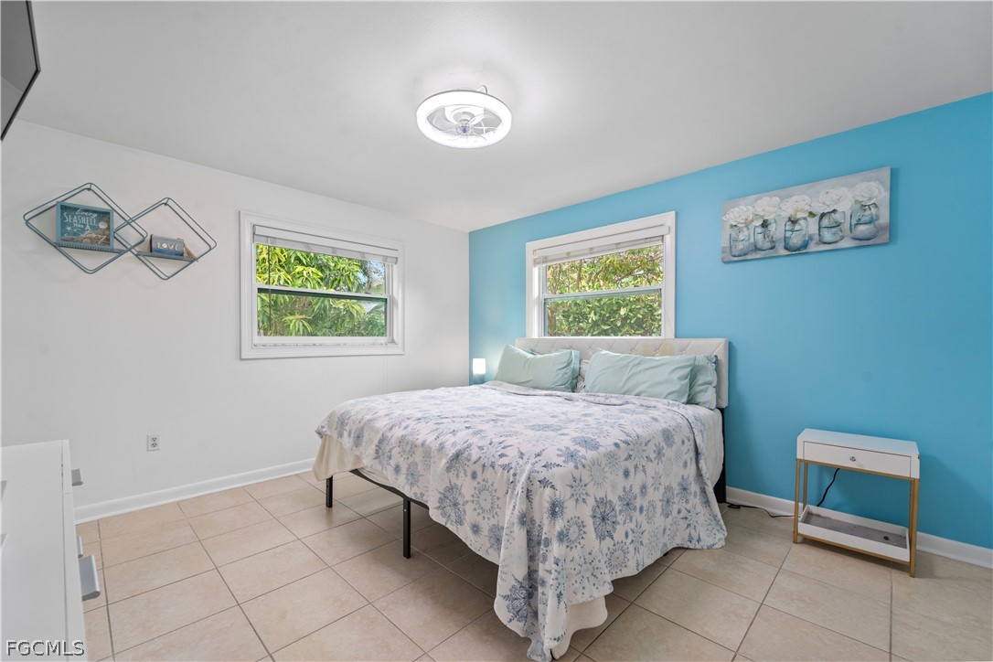 939 Bluebird Street Naples, FL 34104 - Photo 15 of 29 a bedroom with a bed and a table