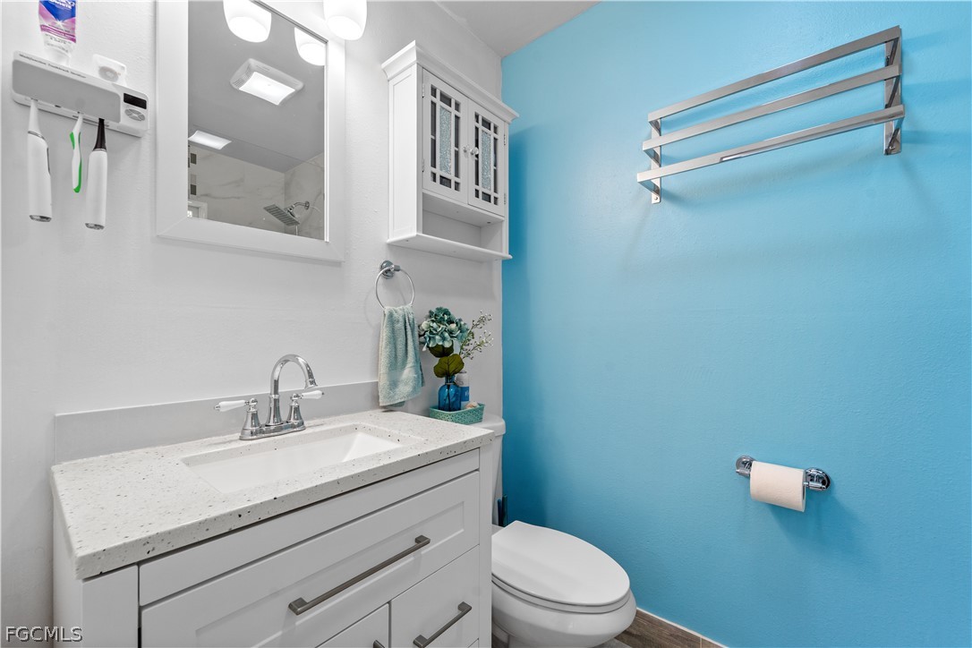 939 Bluebird Street Naples, FL 34104 - Photo 19 of 29 a bathroom with a sink mirror vanity and toilet