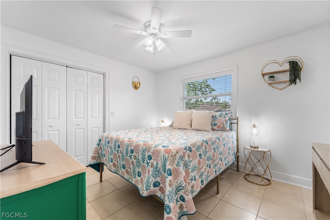 939 Bluebird Street Naples, FL 34104 - Photo 20 of 29 a bedroom with a bed and a chandelier