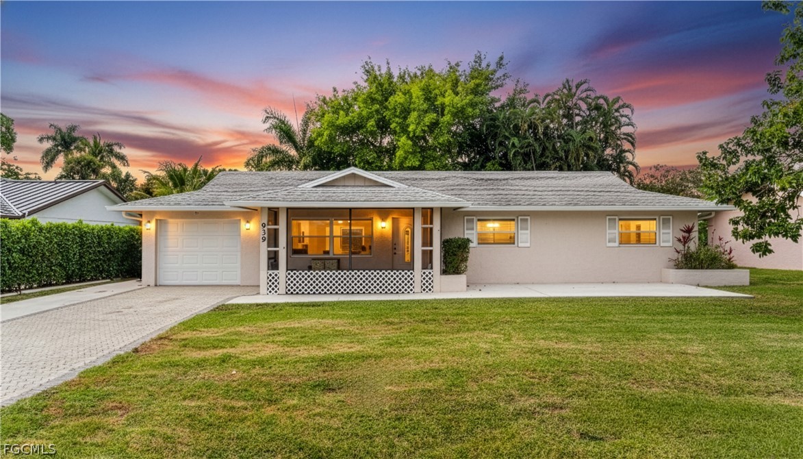 939 Bluebird Street Naples, FL 34104 - Photo 2 of 29 a front view of a house with garage and a yard