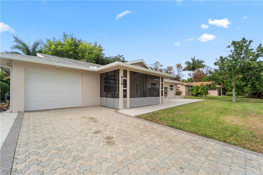 939 Bluebird Street Naples, FL 34104 - Photo 28 of 29 a front view of a house with a garden and yard