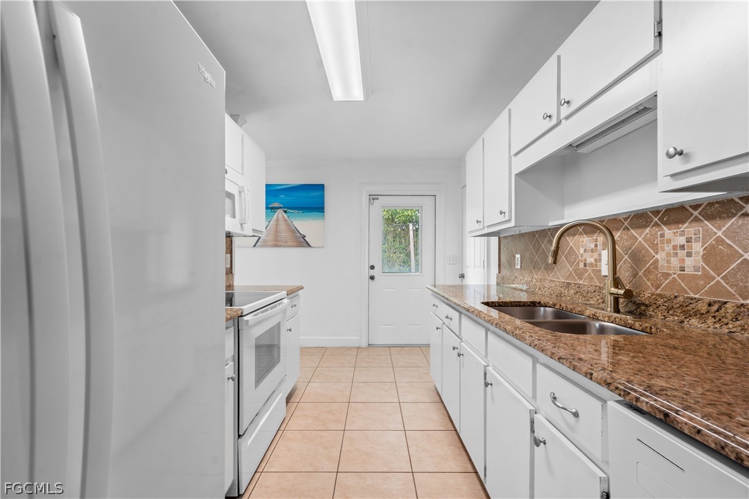 939 Bluebird Street Naples, FL 34104 - Photo 8 of 29 a kitchen with granite countertop a sink and cabinets