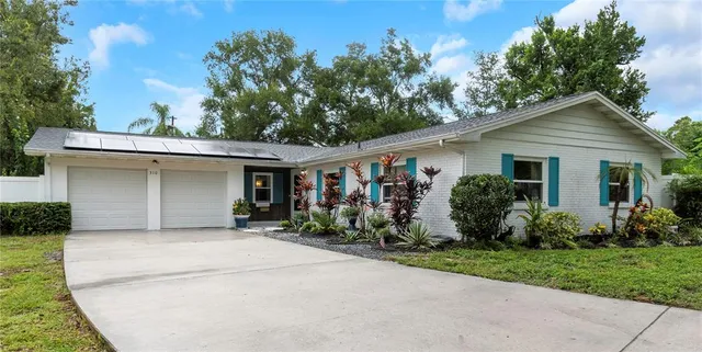 a front view of house with yard and trees in the background