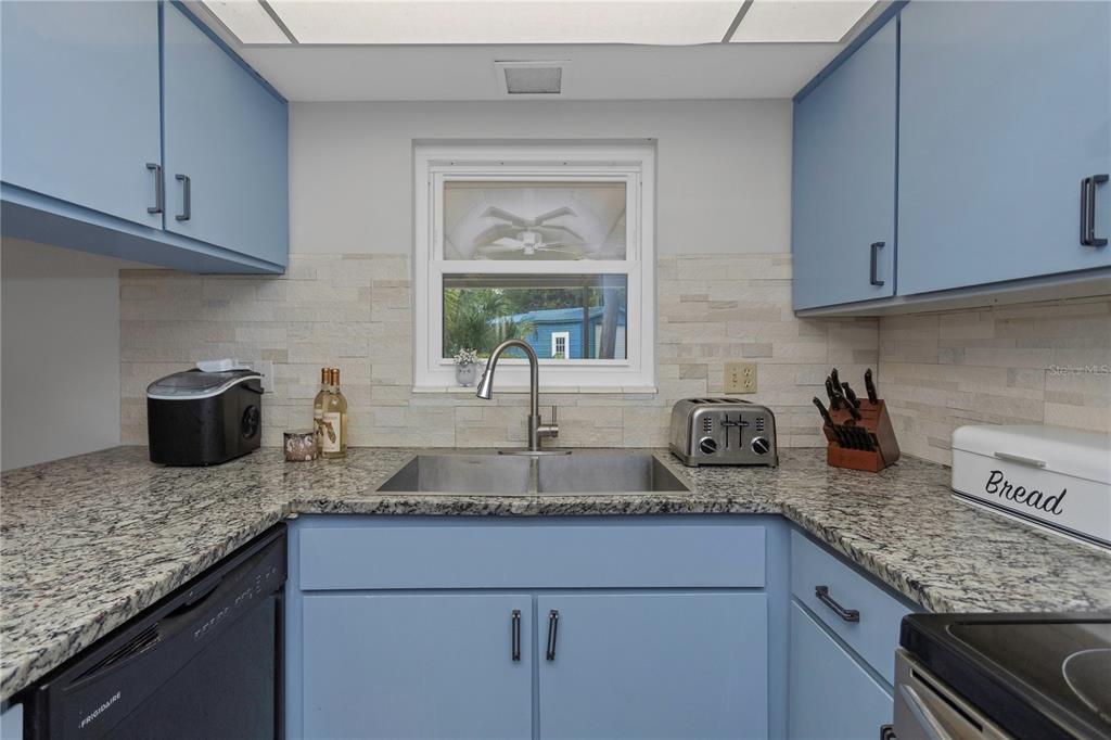310 Terrace Drive Brandon, FL 33510 - Photo 23 of 80 a kitchen with granite countertop stainless steel appliances a sink window and cabinets