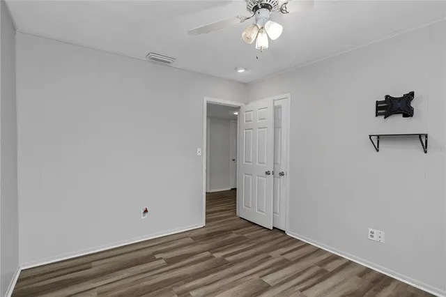 a bedroom with a bed and a ceiling fan