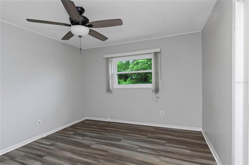 310 Terrace Drive Brandon, FL 33510 - Photo 71 of 80 an empty room with wooden floor fan and windows