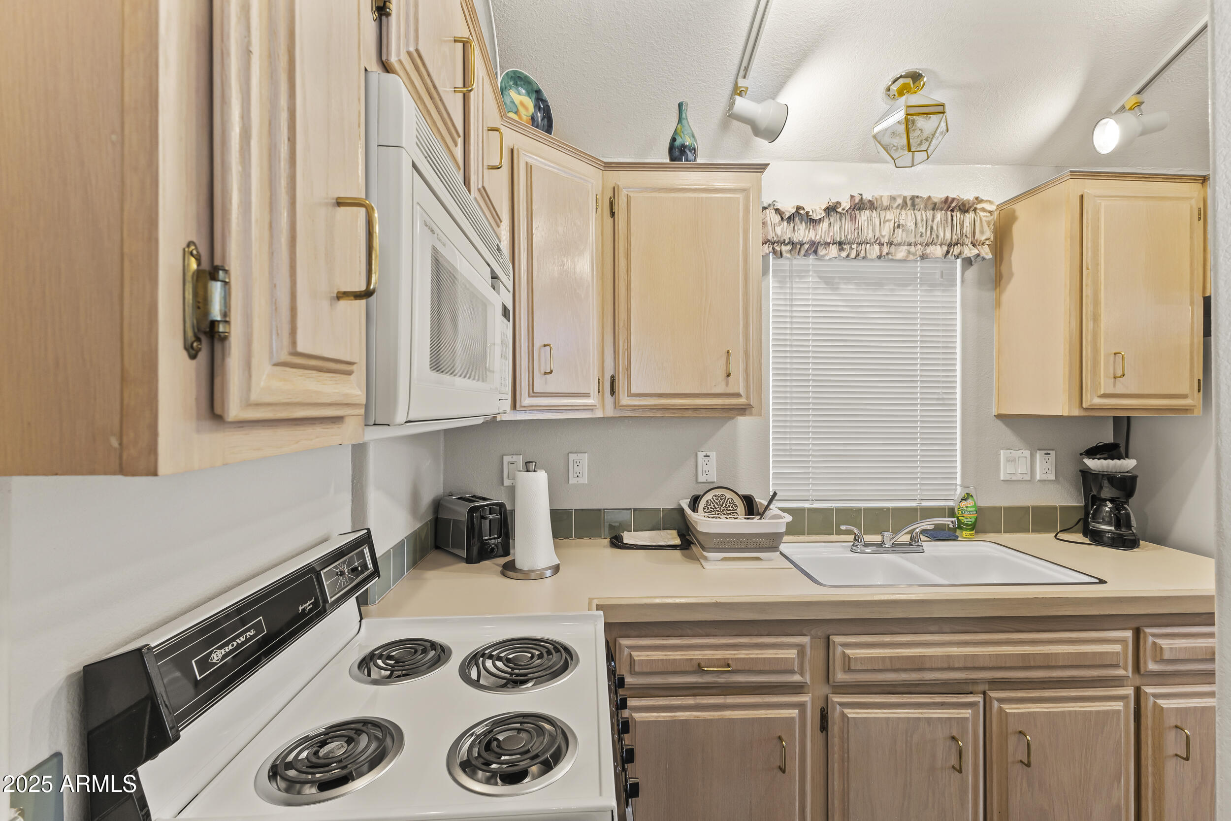 111 South Greenfield Road, Unit 238 Mesa, AZ 85206 - Photo 9 of 20 a kitchen with a sink a stove and cabinets