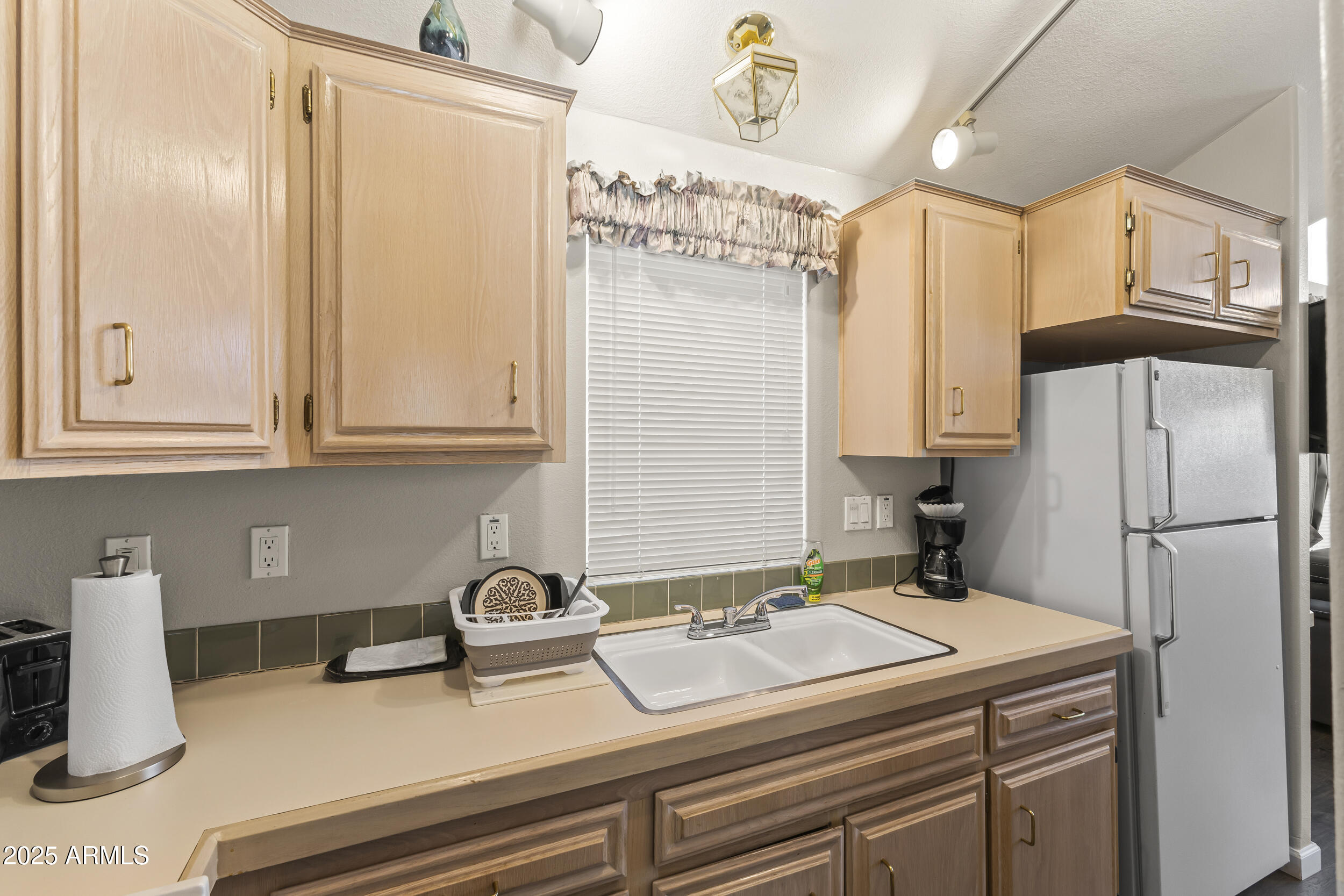 111 South Greenfield Road, Unit 238 Mesa, AZ 85206 - Photo 13 of 20 a kitchen with a sink and a refrigerator