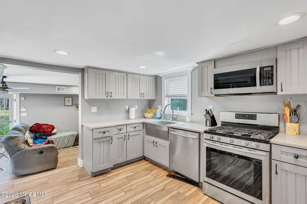 a kitchen with cabinets stainless steel appliances and wooden floor