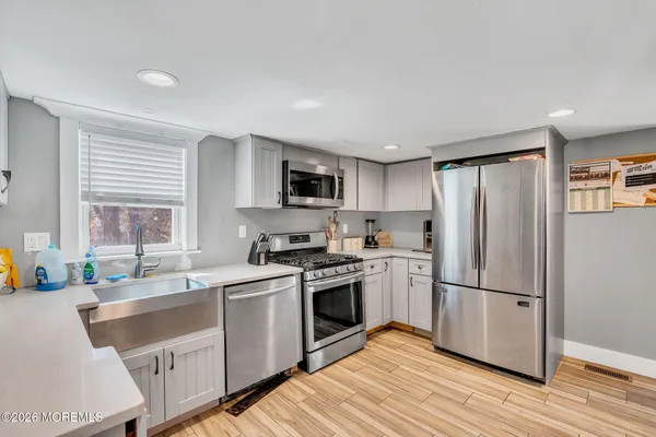 a kitchen with granite countertop stainless steel appliances a sink cabinets and a window
