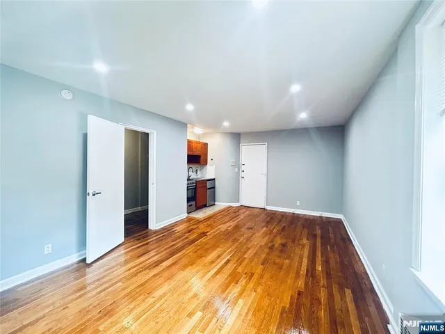 a view of a kitchen with kitchen island granite countertop a refrigerator and a stove top oven