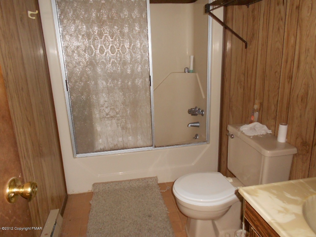 691 Decker Road Bushkill, PA 18324 - Photo 5 of 6 a white toilet sitting next to a bathroom sink and a shower