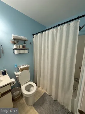 a bathroom with a toilet and a shower curtain