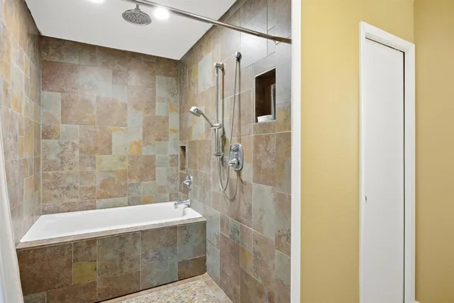 a bathroom with a bathtub and shower