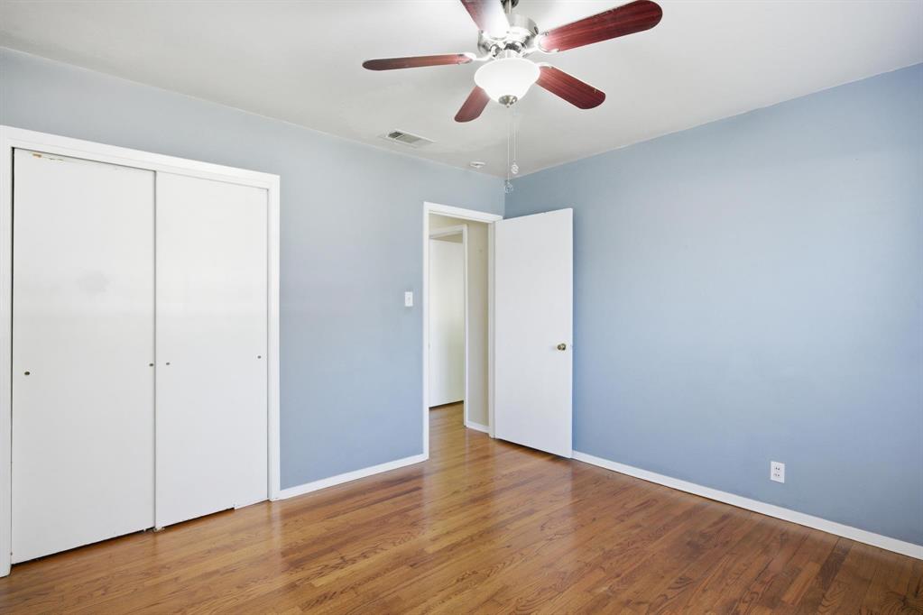 1004 Usher Street Benbrook, TX 76126 - Photo 10 of 25 an empty room with wooden floor closet and fan