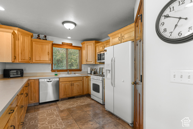 1340 Trapper Loop Garden City, UT 84028 - Photo 12 of 35 Kitchen with stainless steel appliances, light countertops, dark stone finish floors, and recessed lighting
