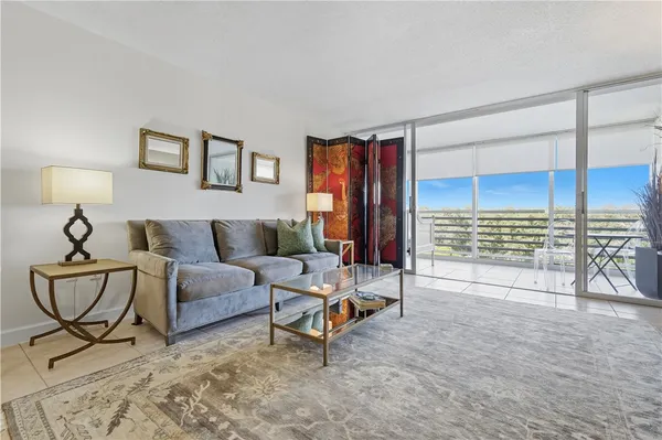 a living room with furniture and a floor to ceiling window