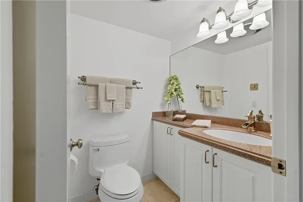 a bathroom with a sink a toilet and a mirror