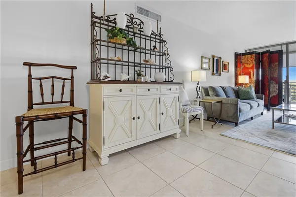 a living room with furniture a window and dresser